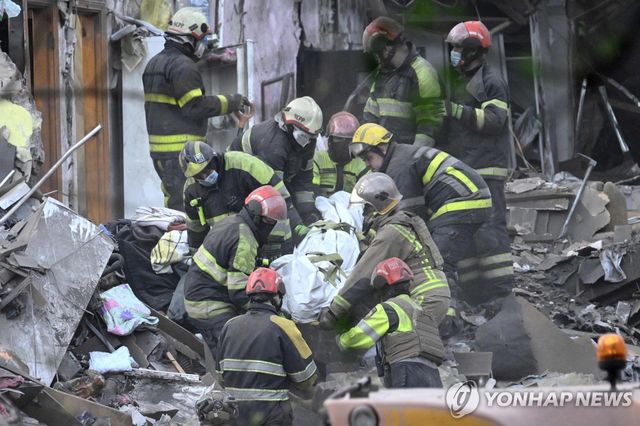 24일(현지시간) 우크라이나 키이우에서 구조대원들이 러시아의 미사일 공습으로 인한 사망자 시신을 수습하고 있다. 