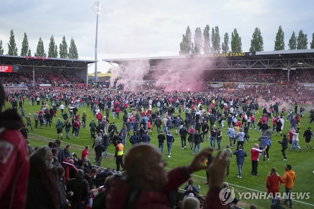 그라운드에서 승격의 기쁨을 나누는 렉섬 팬들