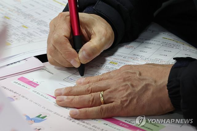 노인 일자리 박람회에서 구직 신청서 작성하는 구직자