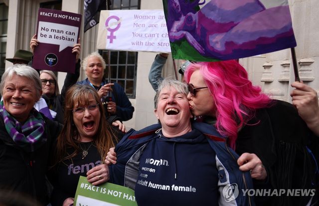 여성 활동가들이 16일(현지시간) 영국 런던 대법원 앞에서 평등법상 '여성'은 생물학적 여성을 뜻한다는 대법원판결에 기뻐하고 있다.