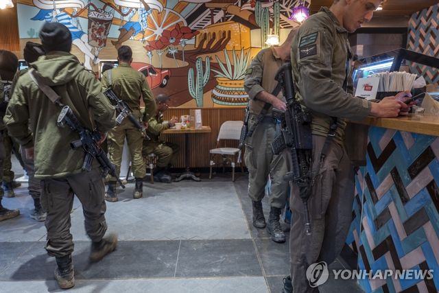 개인화기 소총을 메고 카페를 찾은 이스라엘 군인들