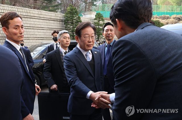 동료 의원과 악수하는 이재명 대표