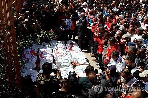 가자지구에서 이스라엘의 총격에 숨진 구호요원들을 추모하는 팔레스타인 사람들 [로이터 연합뉴스. 재판매 및 DB 금지]