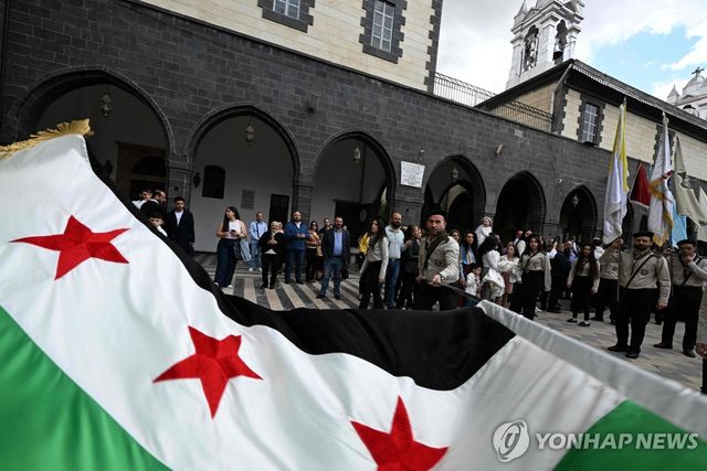 다마스쿠스의 광장에서 시리아 국기를 흔드는 무장 조직원