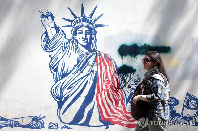 11일(현지시간) 테헤란 시내의 반미 그래피티 앞을 지나가는 시민