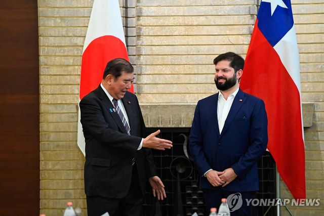 11일(현지시간) 도쿄를 찾은 보리치 칠레 대통령(오른쪽)에게 악수 청하는 이시바 일본 총리