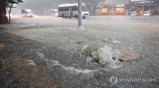 작년 7월 22일 오전 인천 남동구 구월동 시청입구 삼거리 도로 맨홀에서 빗물이 역류하고 있다. [연합뉴스 자료사진]