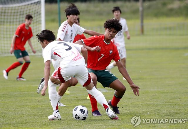 일본 선수를 상대로 볼 경합 중인 호날두 주니어(오른쪽)