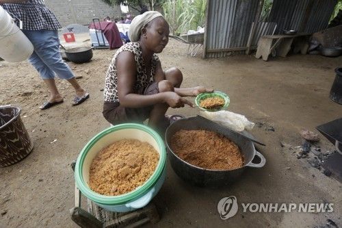 아프리카 서부 라이베리아에서 쌀 요리 '졸로프 라이스'를 준비하는 여성
