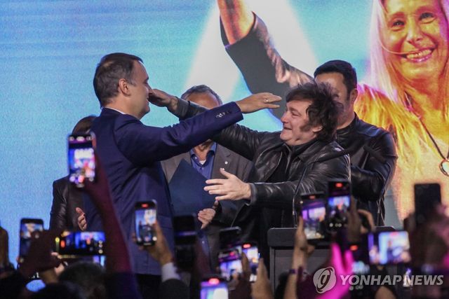 18일(현지시간) 밀레이 아르헨티나 대통령(오른쪽)으로부터 축하 받는 아도르니 대변인