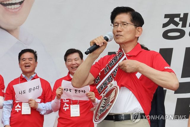 웃옷을 들어 보이는 김문수 후보