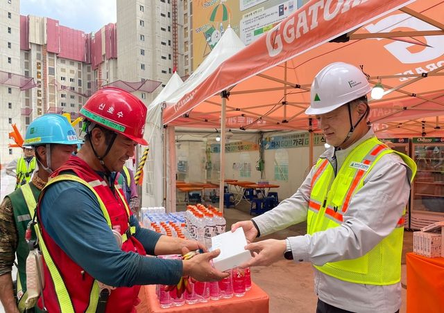 황준하 현대건설 CSO가 21일 서울 은평구 힐스테이트 메디알레 현장에서 근로자에게 이온음료와 쿨링스프레이를 전달하고 있다. [현대건설 제공. 재판매 및 DB 금지]