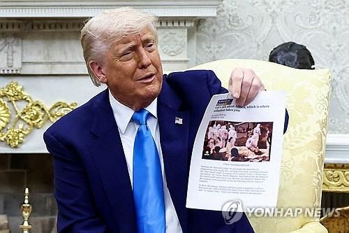 '남아공 백인 학살' 증거라며 기사 인쇄물 들어 보이는 트럼프 대통령