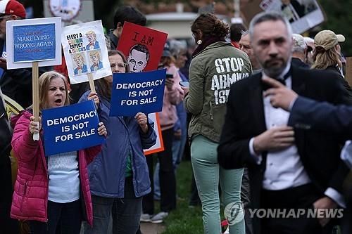 트럼프 가상화폐 디너 행사장 주변의 시위대