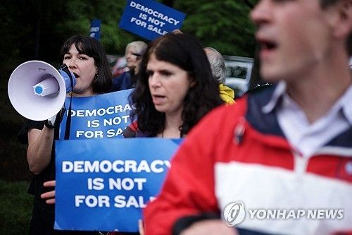 트럼프 밈코인 행사에 항의하는 시위대