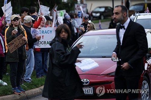 트럼프 밈코인 행사에 항의하는 시위대