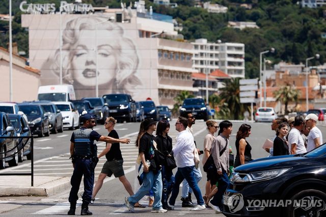 (칸 EPA=연합뉴스) 24일(현지시간) 프랑스 남부 휴양도시 칸에서 정전으로 일부 지역 신호등이 멈춘 가운데 경찰이 교통 지도를 하고 있다.