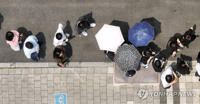 '양산 쓰고 투표 줄서기'