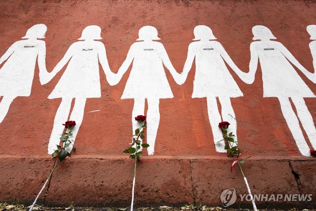여성 살해 피해자들을 상징하는 흰색 실루엣 벽화에 놓인 꽃들