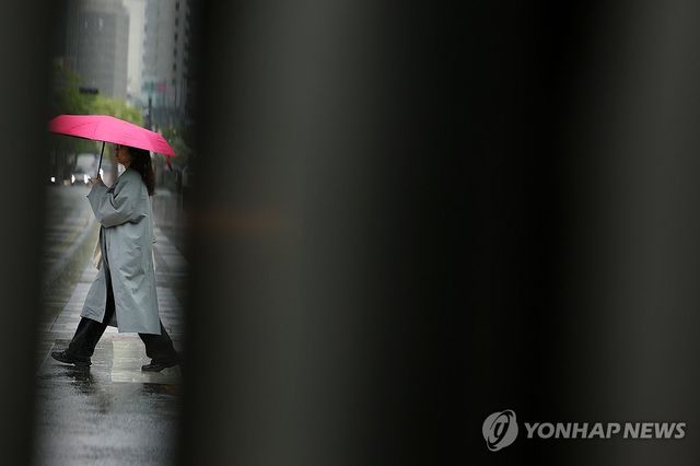 서울 중구 청계광장에서 우산을 쓴 시민이 길을 지나고 있다. [연합뉴스 자료사진]