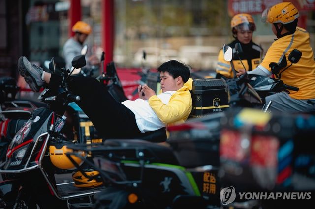 휴식 취하는 중국 상하이의 배달 노동자들