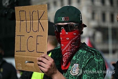 ICE 단속 항의 플래카드 든 시위 참가자