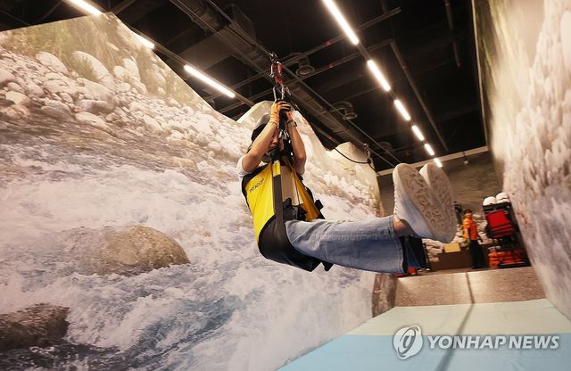 경기 오산시 경기도 국민안전체험관에서 소상공인시장진흥공단 경기남부지역본부 관계자들이 집중호우 등으로 인한 물놀이 안전사고 예방을 위해 계곡 고립 탈출 체험을 하고 있다. [연합뉴스 자료사진]