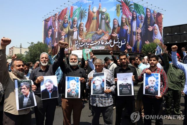 사망한 이란 핵과학자와 군 고위부 사진 들고 있는 시위대