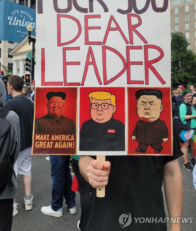 트럼프-김정은 '합성' 만화 그려진 피켓 든 시위 참가자