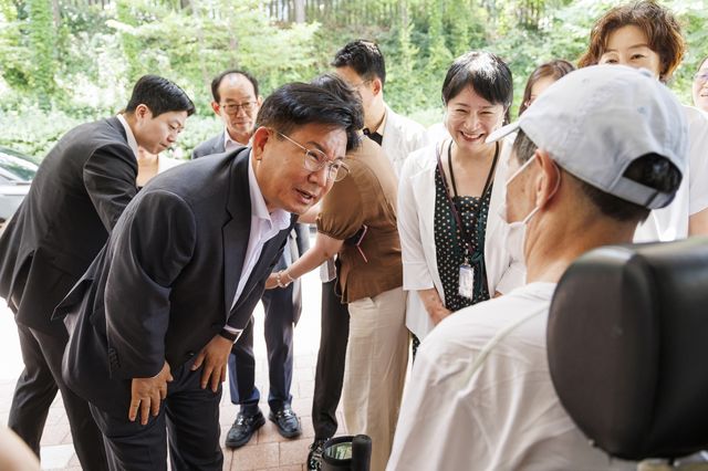 휠체어 탄 어르신과 대화하는 박강수 마포구청장