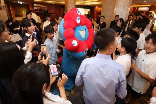 한일 리셉션에서 참석자들에 둘러싸인 오사카 엑스포 캐릭터 먀쿠먀쿠