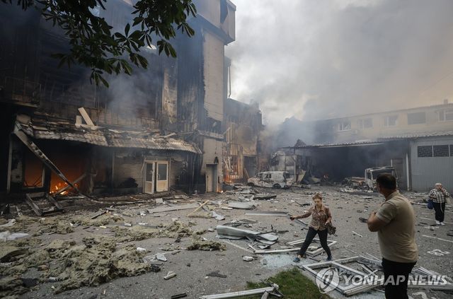 드론 공격으로 파괴된 건물 주변을 지나는 키이우 주민들