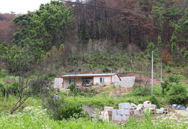 불에 탄 능선 아래 자리 잡은 주택