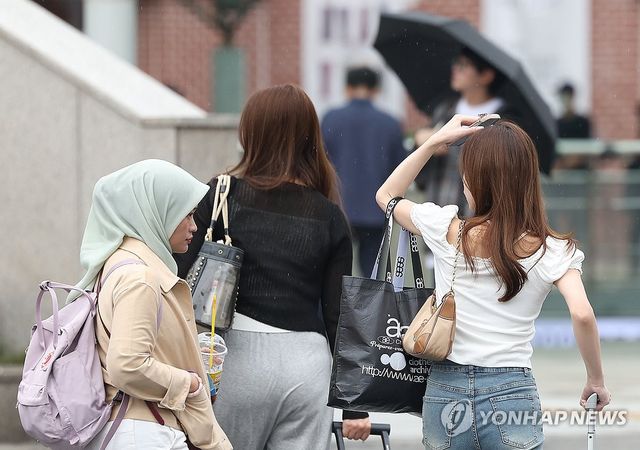 '손으로 비 막으며'