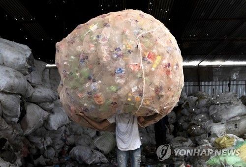 네팔 폐플라스틱 수거회사에서 PET병 옮기는 노동자