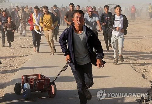 구호품 배급소로 달려가는 가자지구 주민