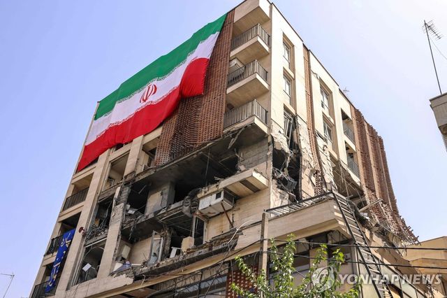이스라엘 공습에 파괴된 테헤란 건물 위에 걸린 이란 국기