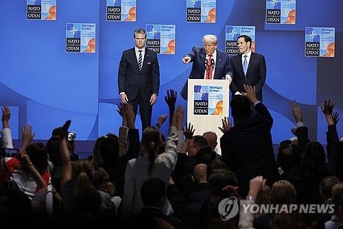 나토 정상회의 기자회견장의 트럼프와 질문하려 손을 드는 기자들