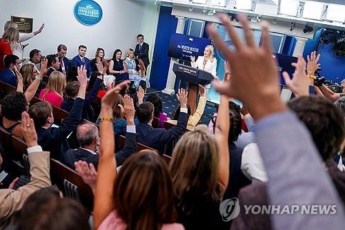 백악관 대변인이 브리핑을 하는 프레스룸에서 질문하려 손을 드는 기자들
