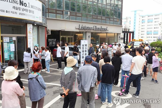 레슬링장에 길게 줄을 선 유권자들