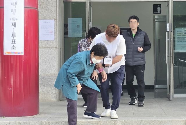 부축받으며 소중한 한표