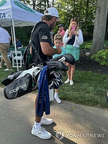 백을 멘 호마가 팬에게 사인해주고 있다. 