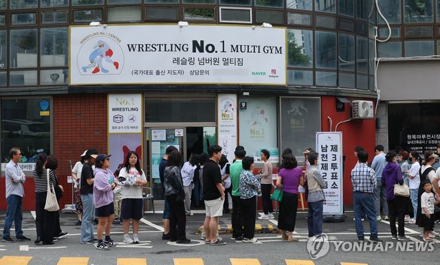 레슬링장에 길게 줄을 선 유권자들