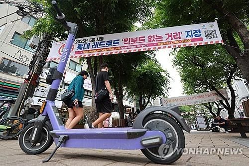 홍대 레드로드에 킥보드 없는 거리 지정 현수막이 걸린 모습