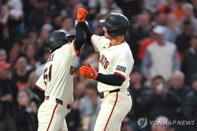 맷 채프먼(오른쪽)과 하이파이브하는 이정후