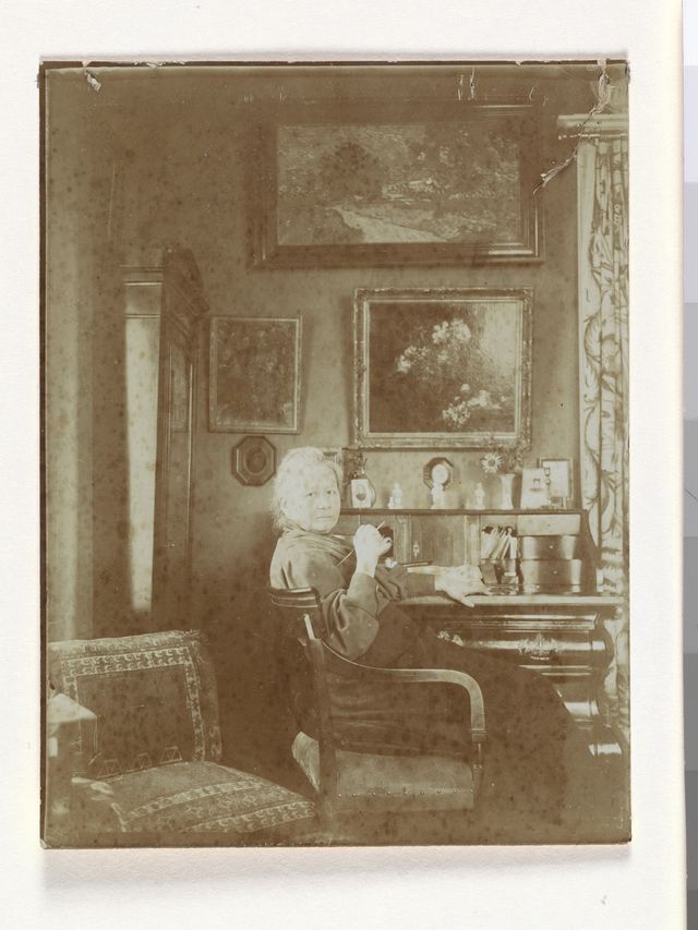 거실 책상 앞의 요 반 고흐 봉어르, 뒤편 벽에 빈센트 반 고흐의 '은선초 꽃병'(1884), '황혼 풍경'(1890) 등이 보인다. [(주)아트북스 제공. 재판매 및 DB 금지]