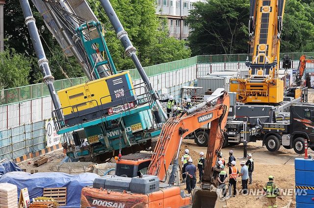 쓰러진 천공기 살펴보는 관계자들