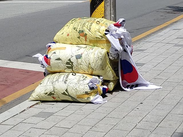 쓰레기봉투에 담겨 버려진 태극기