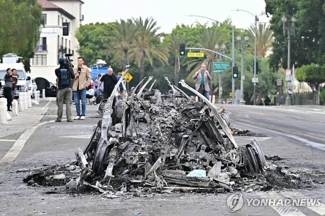 9일 오전 LA 도심에서 웨이모 차량이 불에 타 재만 남은 모습 