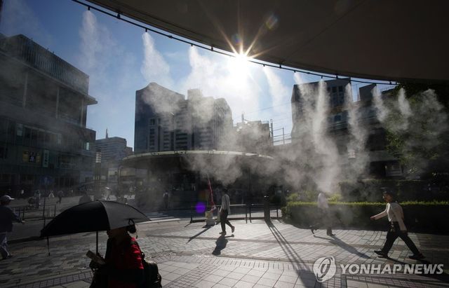 쿨링포그(인공안개) 아래를 지나는 도쿄 시민들